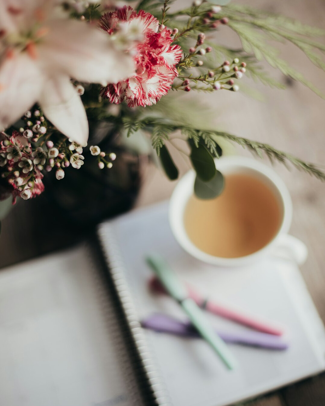 Hand writing in a notebook on a wooden desk